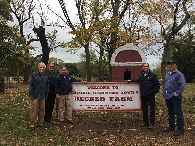 Assemblyman Steve Hawley (R,C,I-Batavia) [left of sign] poses with Assemblyman Michael Cusick (D-Staten Island) [right of sign] at Decker Farms in Staten Island.