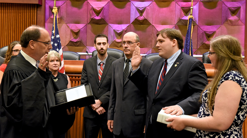 Assemblyman Douglas M. Smith's wife, Elizabeth, holds the Bible as he is sworn in as a Member of Assembly.