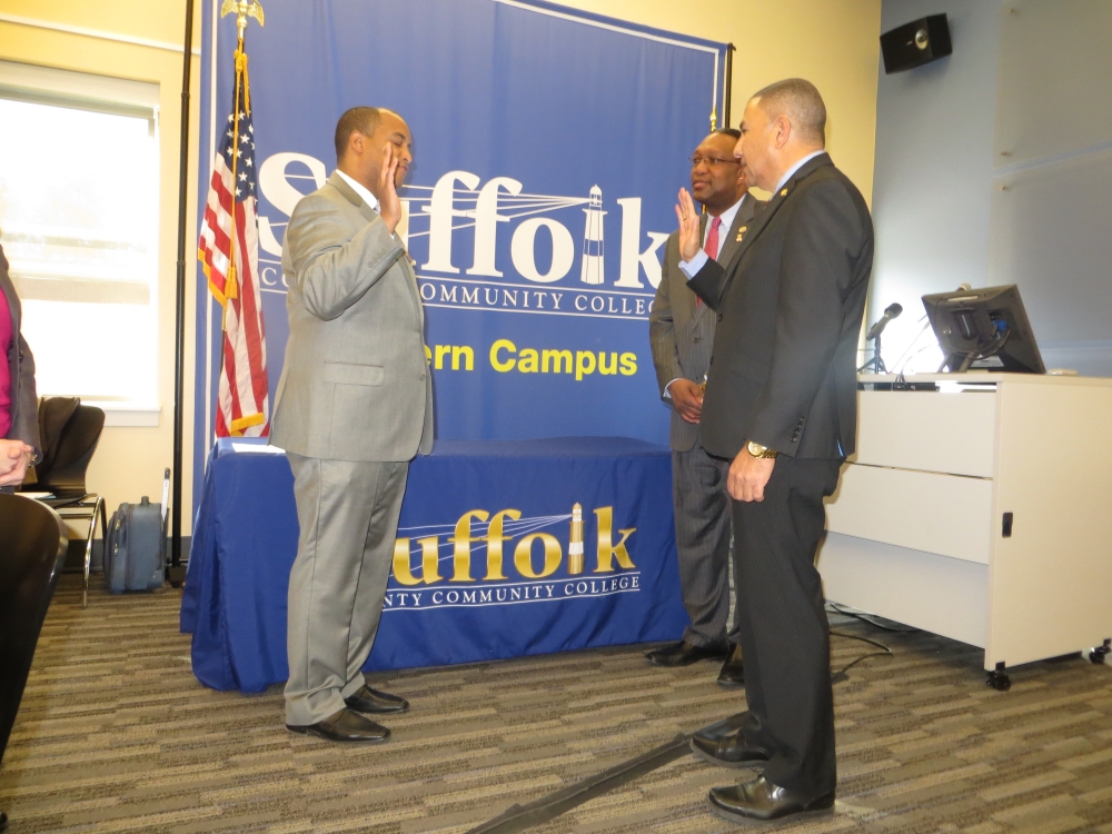 Assemblyman Phil Ramos (right), alongside Dr. Shaun L. McKay, President of SCCC, administers the oath of office to Bergre Escorbores (left) as Trustee of Suffolk County Community College. In addition