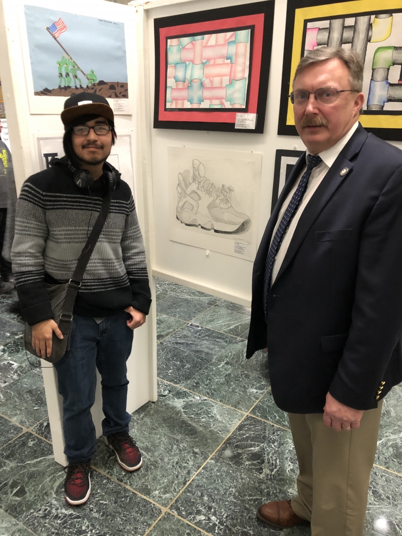 On March 6, 2019, Assemblyman Brian Miller and Demian Martinez Genis pose next to Martinez’s pencil drawing, “Sneaker,” now on display in the Legislative Office Building in Albany.