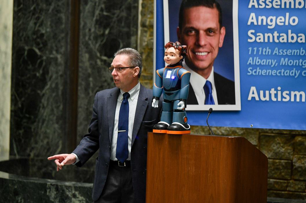 Guest speaker, Milo the robot, addresses attendees at the this year’s Autism Action Day at the New York State Capitol, accompanied by Dr. Gregory Firn of Robokind, developers of “Robots4Autism.”